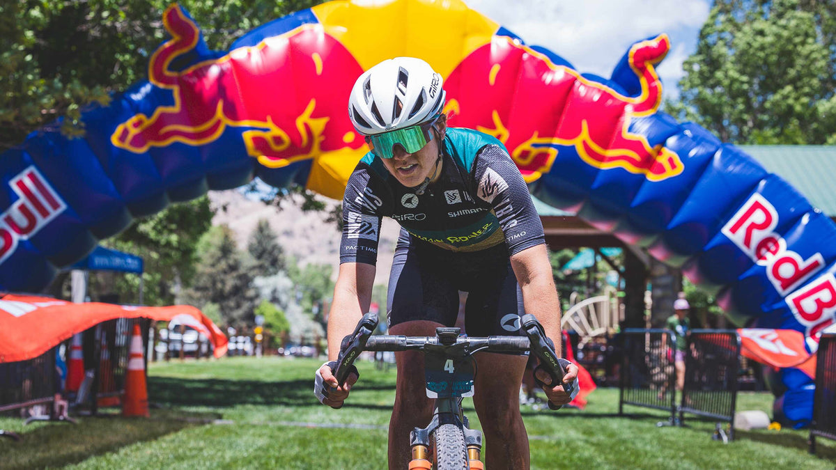 Biker in a racing event with Red Bull inflatable arches in the background